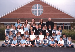 It’s not every school that can capture all its students and teachers in one up-close photograph. Yet that’s what happened when SS. Francis and Clare of Assisi School in Greenwood opened on Aug. 14, 2006. Shown in the top row, from left, instructional assistant Theresa Winter, first-grade teacher Angela Rykowski, kindergarten teacher Mindy Dant, Principal Sandi Patel and Father Vincent Lampert, the pastor of the parish, form the leadership of the newest school in the archdiocese. (Submitted photo) 