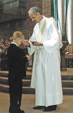 Deacon Thomas Kovatch gives his nephew Thomas Szarkowicz first Communion on May 5 at St. Francis Church in Lake Zurich, Ill. (Submitted photo) 