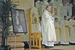 Archbishop Daniel M. Buechlein stands next to a framed portrait of Blessed Teresa of Calcutta at the start of a Mass commemorating the 10th anniversary of her death that was celebrated on Sept. 5 at SS. Peter and Paul Cathedral in Indianapolis.