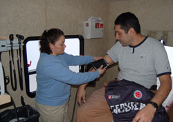 Medical assistant Alma Banegas, left, prepares to take the blood pressure of Francisco Ruiz inside the mobile van of the Gennesaret Free Clinics. The van visits St. Mary Parish in Indianapolis every Saturday to provide medical care to Hispanic immigrants and parishioners. Banegas and Ruiz are members of St. Mary Parish. (Submitted photo)	