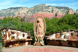 Red rock formations are a stunning backdrop for the Shrine of Our Lady of Guadalupe—Nuestra Senora de Guadalupe—in the Sedona Gardens of St. John Vianney in Arizona, a popular destination for Catholic tourists visiting the Southwest. While enjoying the gardens, visitors can attend Mass at the church. Father J. C. Ortiz, the pastor, is the author of a book of meditations illustrated with color pictures of the beautiful gardens. (Submitted photo courtesy Al Brown)