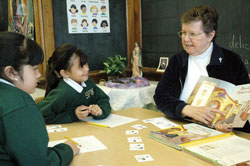 Marisol Canchola, left, and Lorena Luna, both third graders at St. Philip Neri School in Indianapolis, listen to Providence Sister Therese Whitsett on Dec. 11 at the Mother Theodore Catholic Academy. Sister Therese is an English as a New Language teacher at the Indianapolis East Deanery grade school, where many Hispanic children are enrolled. (Photo by Mary Ann Wyand) 