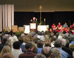 Jesuit Father Fred Kammer delivers a keynote address to the more than 600 participants at the “Spreading Hope in Neighborhoods Everywhere” conference on Oct. 1 in Indianapolis. The priest encouraged participants, in their ministry of charity, to do everything with the love of God in their heart and the look of love on their face. (Photo by Brandon A. Evans) 