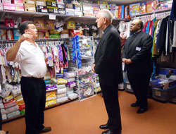 Mark Casper, left, director of St. Elizabeth-Catholic Charities in New Albany, stands in a storeroom at St. Elizabeth’s transitional home on July 27. He is describing to Louisville Archbishop Joseph E. Kurtz and Father Anthony Chandler, pastor of Immaculate Conception Parish in LaGrange, Ky., the many interfaith contributions the agency receives, including baby clothes, diapers and car seats. (Photo by Patricia Happel Cornwell)