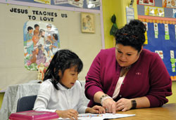 Sarah Watson, principal of the consolidated St. Michael and St. Gabriel elementary schools in Indianapolis, helps kindergartner Mia Rodriguez with an assignment in teacher Lisa Zetzl’s class on Jan. 12 at the Indianapolis West Deanery school. (Photo by Mary Ann Garber)