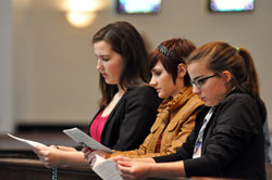 St. Simon the Apostle parishioner and Archdiocesan Youth Council member Annie Fleming of Indianapolis, left, prays the rosary with Our Lady of the Greenwood parishioners Bridget Bard, center, and Corina Defenderfer, right, of Greenwood during a holy hour for vocations to the priesthood and religious life on Dec. 1 at Our Lady of the Greenwood Church. They helped the archdiocesan seminarians lead the gathering of youths, young adults, adults, and men and women religious as part of “A Mission of Prayer—A Year of Faith with Archbishop [Joseph W.] Tobin” at the Indianapolis South Deanery parish. (Photo by Mary Ann Garber)