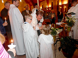Father Anthony Vinson prepares to baptize Joe Dumas, left, and Dale and Amber Kelley at the Easter Vigil on March 30 held at St. Meinrad Church in St. Meinrad for the parishes of St. Boniface in Fulda and St. Meinrad. (Submitted photo)