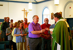 Jack Meany, a member of St. Margaret Mary Parish in Terre Haute, receives Communion from Archbishop Joseph W. Tobin during an Aug. 13 Mass at Sacred Heart of Jesus Church in Terre Haute. Meany and other Catholics from the Terre Haute Deanery involved in the deanery’s planning process and the implementation of that plan came together with the archbishop for the Mass and dinner that followed. (Submitted photo by Patty Mauer)