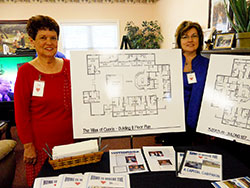 Phyllis Garmon, left, and Brenda Masden, members of the Providence Self-Sufficiency Ministries capital campaign committee, show the designs for two planned additions to the 28-acre Georgetown campus on Sept. 19. An eight-bed unit will be a memory care home, and a 10-bed “villa” or group home will provide skilled care. (Photo by Patricia Happel Cornwell)