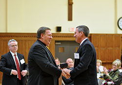 During a meeting of the Catholic Community Foundation (CCF) on Oct. 29 at the Archbishop Edward T. O’Meara Catholic Center in Indianapolis, Archbishop Joseph W. Tobin presents George Kempf with a gift of appreciation for his five years of service on the foundation’s board of trustees and as a volunteer advisor on the CCF professional advisory group. (Photo by Natalie Hoefer)
