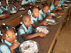 Students at St. Francis Xavier School in Gandou, Haiti, enjoy a meal made available by the school lunch program sponsored by St. Anthony of Padua Parish in Morris. (Submitted photo)