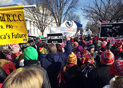 Participants in the 42nd annual March for Life carry signs and chant pro-life slogans as they march toward the U.S. Supreme Court building in Washington on Jan. 22, the anniversary of the legalization of abortion in the United States. (Photo by Michaela Raffin)