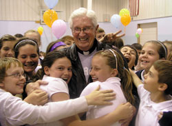 Father James Wilmoth’s popularity with the students at St. Roch School in Indianapolis is evident during a schoolwide tribute to him in 2010, shortly after he received the Distinguished Pastor Award from the National Catholic Educational Association. (File photo by John Shaughnessy)