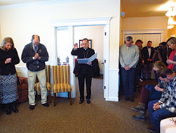 Archbishop Charles C. Thompson blesses the Women’s Care Center in Bloomington on March 7 while supporters, staff, volunteers and donors bow in prayer. Nearly 50 people gathered for the dedication of the facility. (Photo by Katie Rutter)