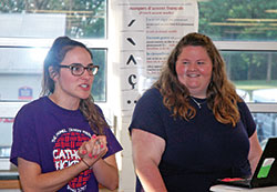 Julia Puscas, left, and Meghan Gehrich are young adult Catholics who love and live their Catholic faith. Here, Puscas introduces Gehrich, the youth ministry coordinator at St. Mary Parish in Greensburg, before she shared a faith-related talk with the teenagers who participated in the archdiocese’s Homeland Mission program during the week of June 11-15. Puscas coordinated the program in which teenagers from across the archdiocese spend the week serving the poor and vulnerable in Indianapolis. Gehrich shared her talk in a classroom at Roncalli High School in Indianapolis. (Photo by John Shaughnessy)