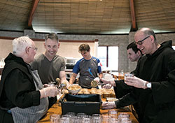 Monks work in the monastery dining room at Saint Meinrad Archbabbey to fill jars with freshly made peanut butter. (Photo courtesy of Saint Meinrad Archabbey)