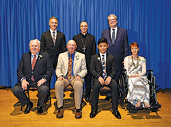 Catholic Charities Indianapolis presented four individuals with Spirit of Service Awards during an April 30 dinner in Indianapolis. Award recipients, seated from left, are James Morris, Robert “Lanny” Rossman, Yan Yan and Liz Stanton. Standing, from left, are keynote speaker Ed Carpenter, Archbishop Charles C. Thompson and David Bethuram, executive director of the archdiocese’s Catholic Charities. (Submitted photo by Rob Banayote)