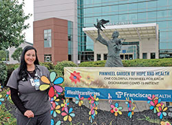 Annie Burford stands amid the Pinwheel Garden of Hope and Health at Franciscan Health Indianapolis where each pinwheel represents a COVID-19 patient who has returned to health. Burford is a respiratory clinical specialist at the hospital. (Photo by John Shaughnessy)