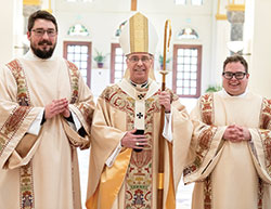 Transitional Deacon Michael Clawson, left, and transitional Deacon Matthew Perronie pose on April 10 with Archbishop Charles C. Thompson after a Mass at the Archabbey Church of Our Lady of Einsiedeln in St. Meinrad during which the deacons and three other men were ordained transitional deacons. Deacon Clawson is a member of Annunciation Parish in Brazil. Deacon Perronie is a member of St. Malachy Parish in Brownsburg. (Photos courtesy of Saint Meinrad Archabbey)