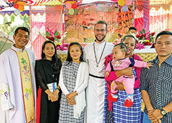 Holy Cross Brother Jimmy Henke, center, poses on Dec. 25, 2021, after a Christmas Mass in Srimangal, Bangladesh, with Holy Cross Father Kevin Kubi, left, and a family whose baby was baptized during the liturgy. Brother Jimmy is a graduate of Roncalli High School in Indianapolis. (Submitted photo)