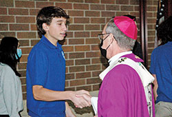 Archbishop Charles C. Thompson greets a student after the annual Archdiocesan High School Senior Mass on Dec. 1, 2021, at St. Malachy Church in Brownsburg. (Photo by John Shaughnessy)