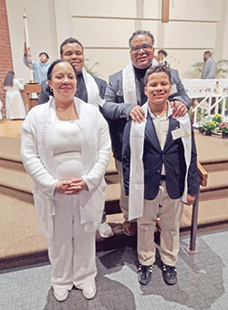 The Toliver family smiles in St. Lawrence Church in Indianapolis after being received into the full communion of the Church during the parish’s Easter Vigil Mass on April 8. In the front row are June, left, and Justin. In the back row are Sidney, left, and Ramon. (Submitted photo)