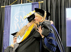 Dottie King gives a hug to a graduate of Saint Mary-of-the-Woods College in St. Mary-of-the-Woods during a May 2023 commencement ceremony. After 13 years as president of the college, King stepped down from that post at the end of June. (Submitted photo)