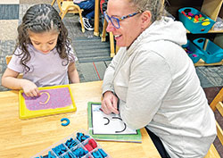 Katryn Kutan, director of early childhood education at St. Lawrence School in Indianapolis, works with Nahomy Brigitte Sanchez, a student in the program. (Submitted photo)