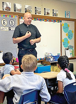 Father Timothy Wyciskalla, pastor of St. Mark the Evangelist Parish in indianapolis, often visits with students at the parish’s school to share stories and lessons about the Catholic faith. (Submitted photo)