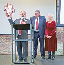 During a banquet on Feb. 25 in Indianapolis celebrating 20 years of broadcasting, Catholic Radio Indy general manager Gordon Smith holds a San Damiano Cross award before presenting it to Bob and Sharon Teipen for their efforts in starting and supporting Catholic Radio Indy since its inception in 2004. (Photo by Natalie Hoefer)