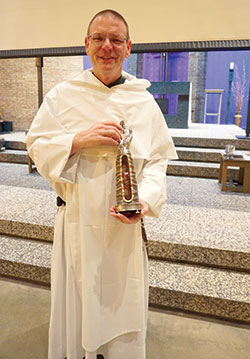Father Michail Ford, OP, holds the reliquary containing a relic of St. Jude Thaddeus, one of the 12 apostles. The relic is a piece of bone from the saint’s arm. “Relics serve as a connection with the communion of saints,” Father Ford said during a presentation at St. Thomas Aquinas Parish in West Lafayette. (Photo by Caroline B. Mooney)