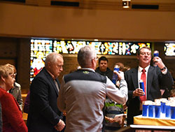 St. Matthias Hope Ministry committeeman Tim Kreke (right) helps locate personalizaed candles for bereaved guests at the second annual "We Remember" service at the Crown Point church on Feb. 21. Ministry members offered an ecumenical program of scripture reading, song and other commemorations for those who have lost a child. (Anthony D. Alonzo photo)