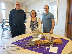 Father Gerald Borawski and Karen and Dan Held pose for a photo with some of the items that are part of the couple’s Easter traditions from Karen’s Polish heritage. (Photo by Caroline B. Mooney)