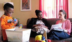 Raina, who recently was accepted into the Bridge of Hope program, works with Family Resource Coordinator, Kristi Kubicki, MSW, for Bridge of Hope at Hannah’s House to set up a workable budget while her young son, TyeRon, plays near her. The two women will meet regularly as part of the program. This meeting was held in the living room area at Hannah’s House in Mishawaka on Fourth Street.