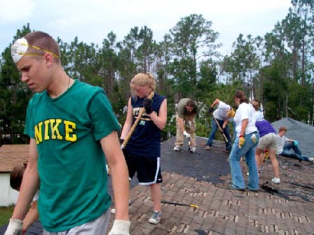 volunteers tearing down a roof