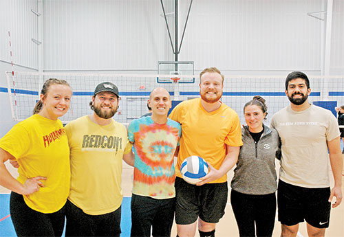 IndyCatholic volleyball league offers a winning combination of community, faith and friendship for young adults, including the teammates of “The Yellow Swarm”: Allison Hildebrand, left, Kurtis Wagner, Derek Sanders, Kevin Bedel, Mary Kate Thatcher and Michael Frausto. (Photo by John Shaughnessy)