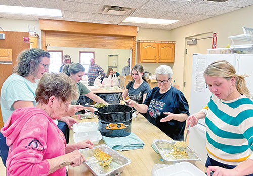 Members of St. Gabriel Parish in Connersville prepare a dinner to be shared with those in need in the local community in this photo from March 2023. While it is a charitable effort, it also serves as an opportunity to evangelize, sharing Christ’s love and good news as the parishioners eat with those being served. (Submitted photo)
