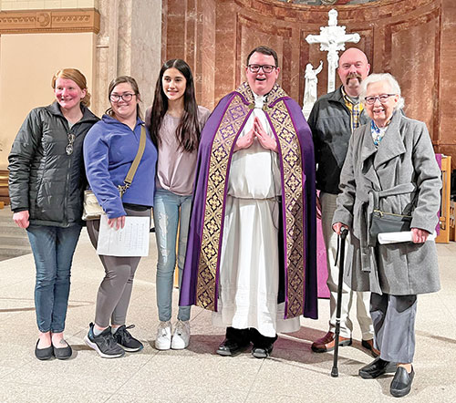 Following the Rite of Election at SS. Peter and Paul Cathedral in Indianapolis on Feb. 18, Dolores Kopp, right, poses with cathedral rector Father James Brockmeier, third from right, and other catechumens and candidates of St. Anthony of Padua Parish in Clarksville: Kirsten Nalley, left, Kylee Cornwell, Melanie Dixon and Brandon Skaggs. (Submitted photo)