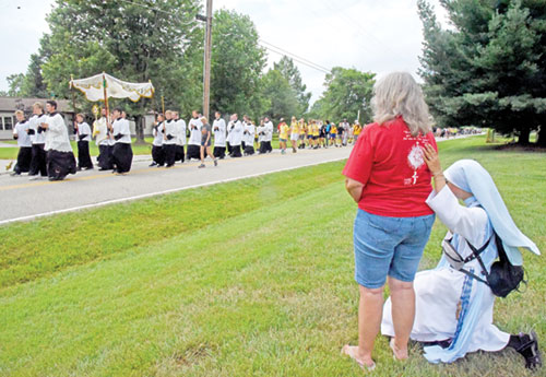 Daughter of Mary Mother of Healing Love Sister Mary Fatima Pham prays with Sue Widolff on July 9 as a 3-mile eucharistic procession that was part of the east route of the National Eucharistic Pilgrimage makes its way through Dearborn County. (Photo by Sean Gallagher)