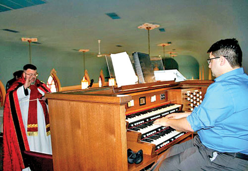 Father Jerry Byrd, pastor of St. Mary Parish in North Vernon and St. Ann and St. Joseph parishes, both in Jennings County, blesses the new organ that St. Mary was able to purchase through a grant from the James P. Scott Endowment Fund of the Catholic Community Foundation of the Archdiocese of Indianapolis. Music Director Seth Jines is also pictured. (Submitted photo by Jennifer Lindberg)