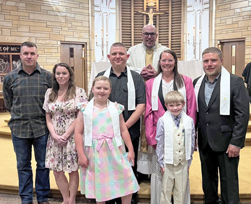Moved in part by their experience of Catholicism through having children enrolled in St. Rose of Lima School in Franklin, three families were welcomed into the full communion of the Church during the Easter Vigil Mass on April 19 at St. Rose of Lima Church. They are Widd and Jamie Lewis, left, Zahra and Zackery Estes, and Bethany, Xander and James Skaggs. Standing behind them is Father Timothy DeCrane, pastor of the parish. (Submitted photo)