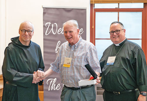 Benedictine Father Denis Robinson, president-rector of Saint Meinrad Seminary and School of Theology in St. Meinrad, left, congratulates Daniel Conway on Aug. 5 after he received the Distinguished Alumnus Award at Saint Meinrad. Pictured at right is Father Matt Gerlach of the Diocese of Tulsa, Okla., who is the president of the Saint Meinrad Alumni Association Board of Directors. (Photo courtesy of Saint Meinrad Archabbey)