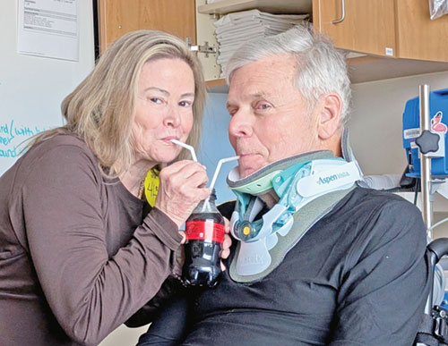 Kathy and John Bannister of Immaculate Heart of Mary Parish in Indianapolis sip from a Coke together during his rehabilitation earlier this year at Craig Hospital near Denver, after his horrifying accident while skiing in Colorado. (Submitted photo)