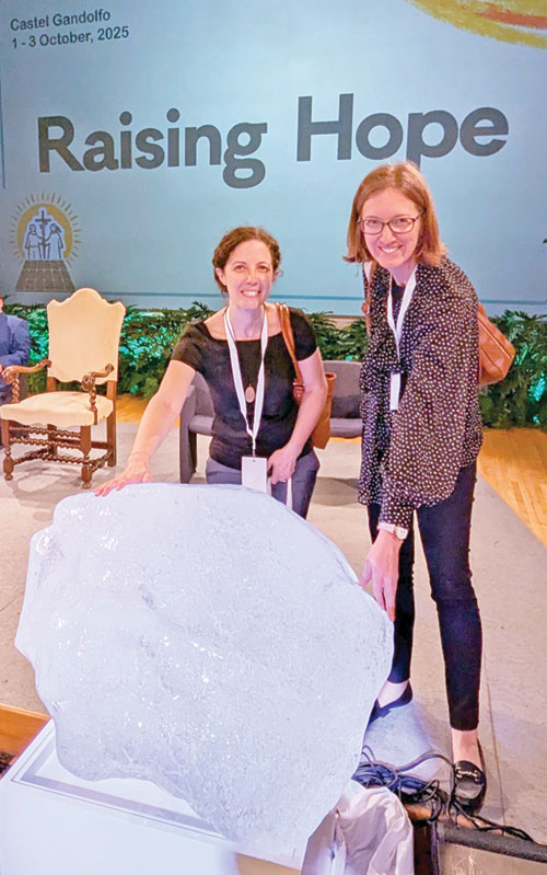 Sarah Mundell Spencer, left, and Julie Reyes, members of the archdiocesan Creation Care Ministry, touch a piece of a glacier from Greenland during the Raising Hope for Climate Justice Conference held in Castel Gandolfo, Italy, on Oct. 1-3. (Submitted photo)