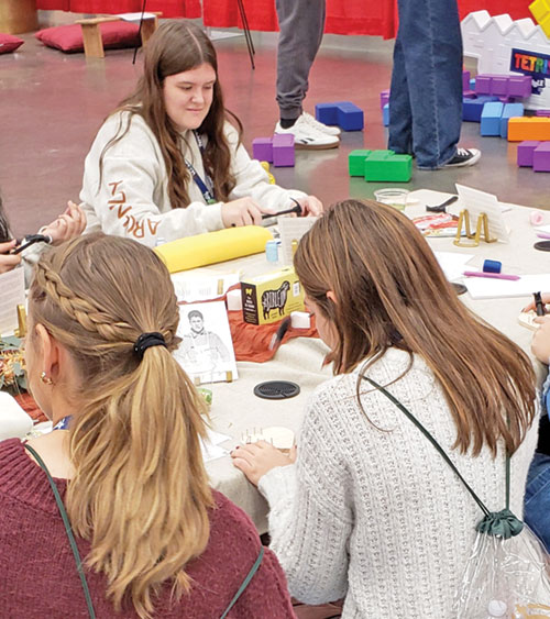 Libby Berg of St. Pius X Parish in Indianapolis, top, enjoys an activity in an area of the interactive exhibit hall in the Indiana Convention Center in Indianapolis on Nov. 22 during the National Catholic Youth Conference. (Photo by Natalie Hoefer)