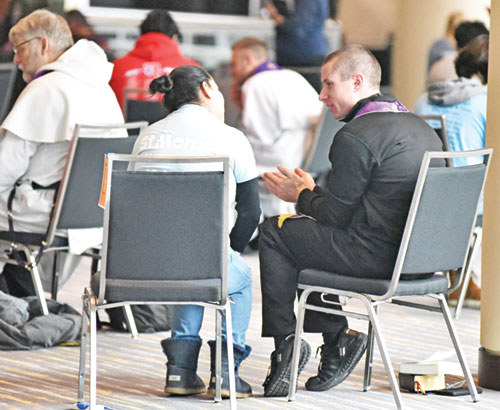 A priest hears the confession of a participant at the Indiana Youth Rally for Life on Jan. 22 at the Indiana Convention Center in Indianapolis. (File photo by Sean Gallagher)