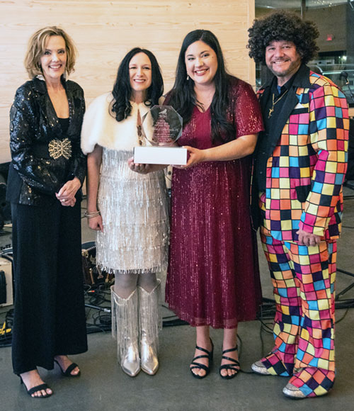 Gabriela Ross, archdiocesan director of the Office of Marriage and Family Life, second from right, accepts Red Bird Ministries&rsquo; Mission Star 2026 Chapter of the Year Award during the organization&rsquo;s Boogie-with-the-Birdies event in Broussard, La., on April 17 (based this year on a disco theme). With her are the organization&rsquo;s board chair Janet Morein Wood, left, and co-founders Kelly and Ryan Breaux. Red Bird Ministries is a non-profit organization providing resources&mdash;through a Catholic lens&mdash;to those who have experienced the loss of a child from pre-born through adult. (Submitted photo courtesy of Hannah Louise Photography of Lafayette, La.)
