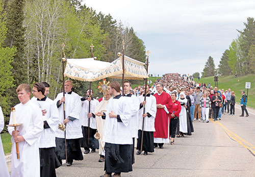 Bishop Andrew H. Cozzens of Crookston, Minn., processes with the Eucharist to the headwaters of the Mississippi River in Itasca State Park May 19 for the launch of the Marian Route of the National Eucharistic Pilgrimage. (OSV News photo/Courtney Meyer)