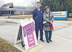 Larry Kunkel, left, and Margie Schmitz serve as Sidewalk Advocates for Life volunteers at the Planned Parenthood facility in Indianapolis, where women go for abortion referrals, birth control, “morning after” emergency contraception and other services in opposition to the sanctity of life. (Photo by Natalie Hoefer)