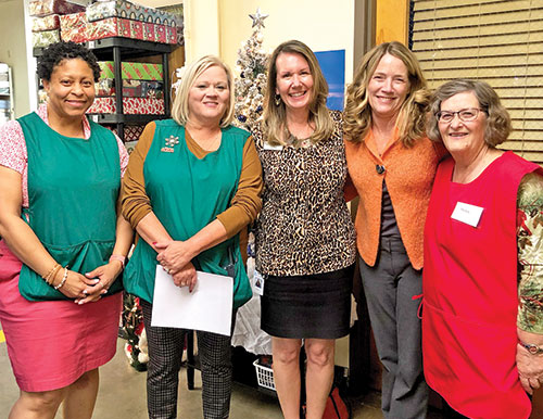 As the longtime director of the Crisis Office and the Christmas Store for Catholic Charities Indianapolis, Stephanie Davis, second from left, had a gift for surrounding herself with friends, co-workers and volunteers who shared her dedication to helping people in need. Here, she poses for a photo at the Christmas Store with Simata Wilcox, left, Cheri Bush, Eileen Dennie and Helen Burke.  (Submitted photo)